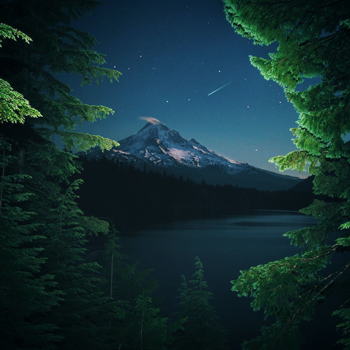 Photo by Lance Reis a night scene of a mountain and a lake